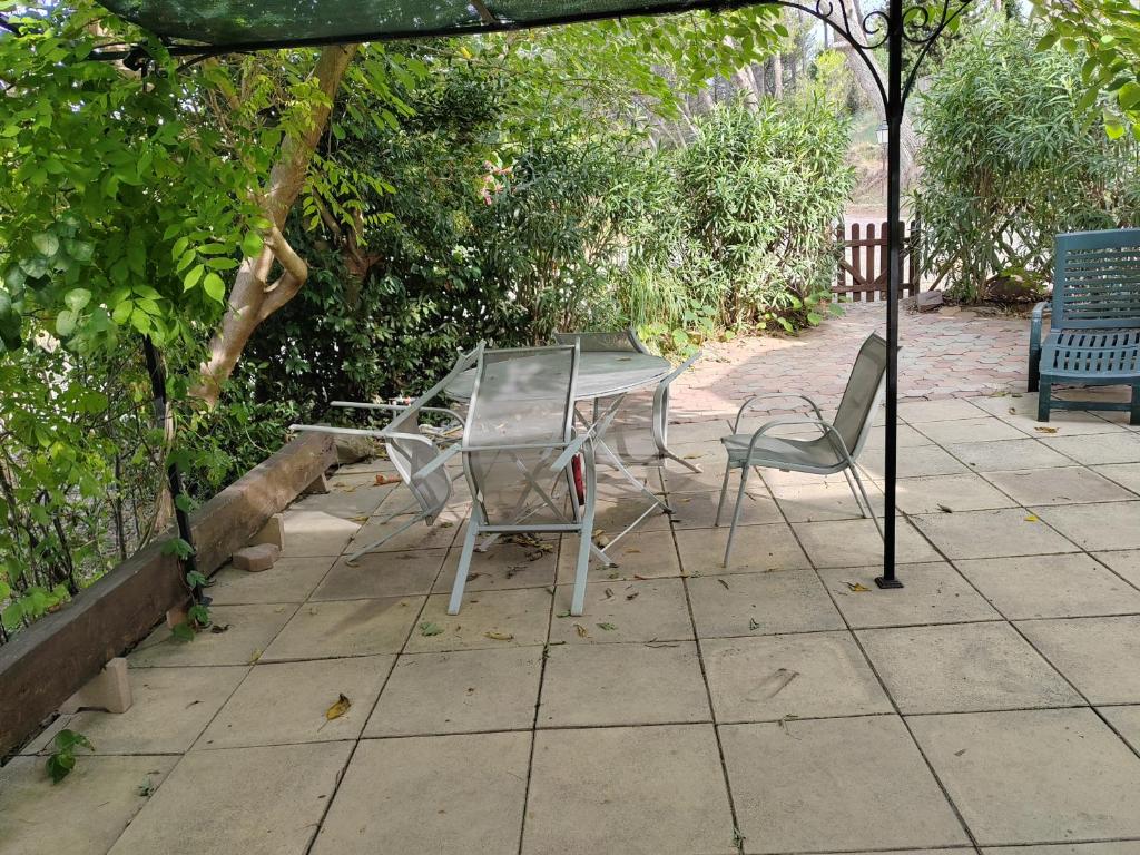 une table et des chaises assises sous un parasol dans l'établissement chez martine, à Saint-Mitre-les-Remparts