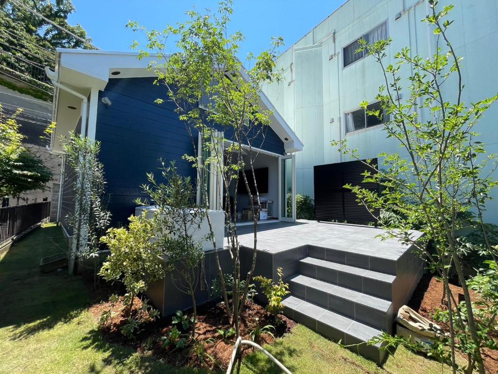 ein Haus mit einer blauen Wand und einer Treppe in einem Hof in der Unterkunft Timeless House Hashirimizu in Yokosuka