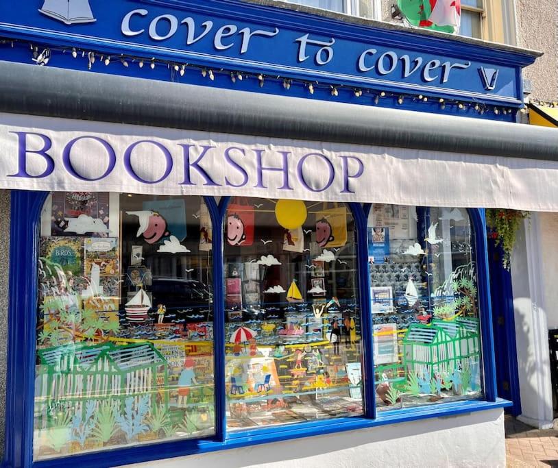 een winkel voor een boekwinkel met een bord erop bij The Bookshelf, Mumbles. in Oystermouth
