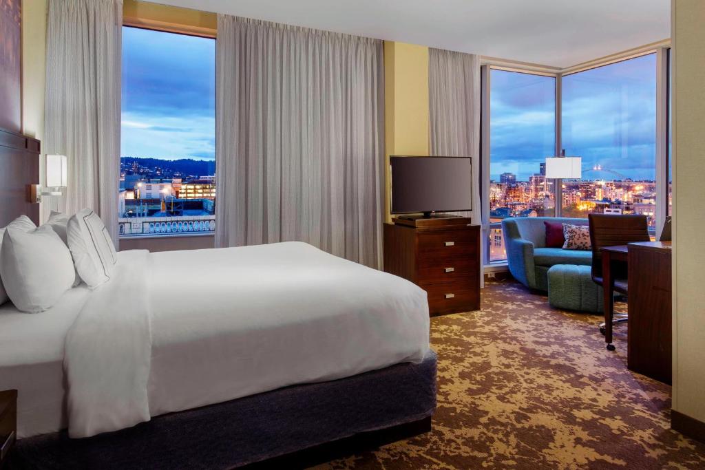 ポートランドにあるCourtyard by Marriott Portland City Centerのベッド付きのホテルルームで、市街の景色を望めます。