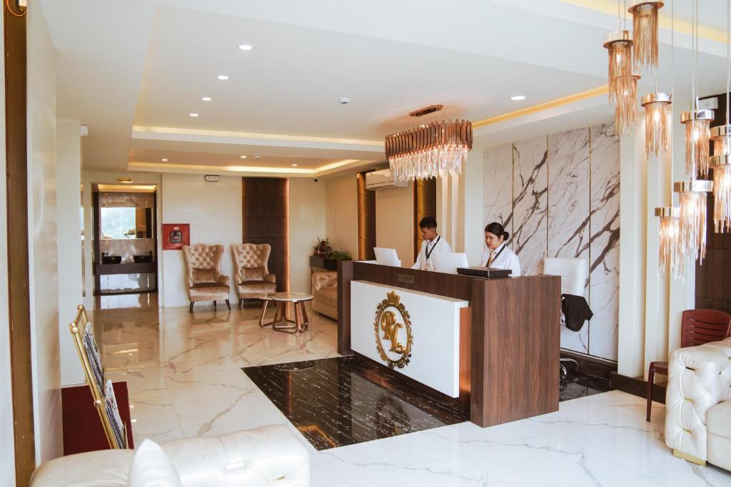 dos personas sentadas en una recepción en el vestíbulo del hotel en ROYALE LALAWI HOTEL, en Āīzawl