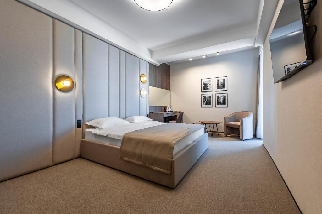 - une chambre avec un lit, un bureau et une chaise dans l'établissement Regency Hotel, à Chişinău