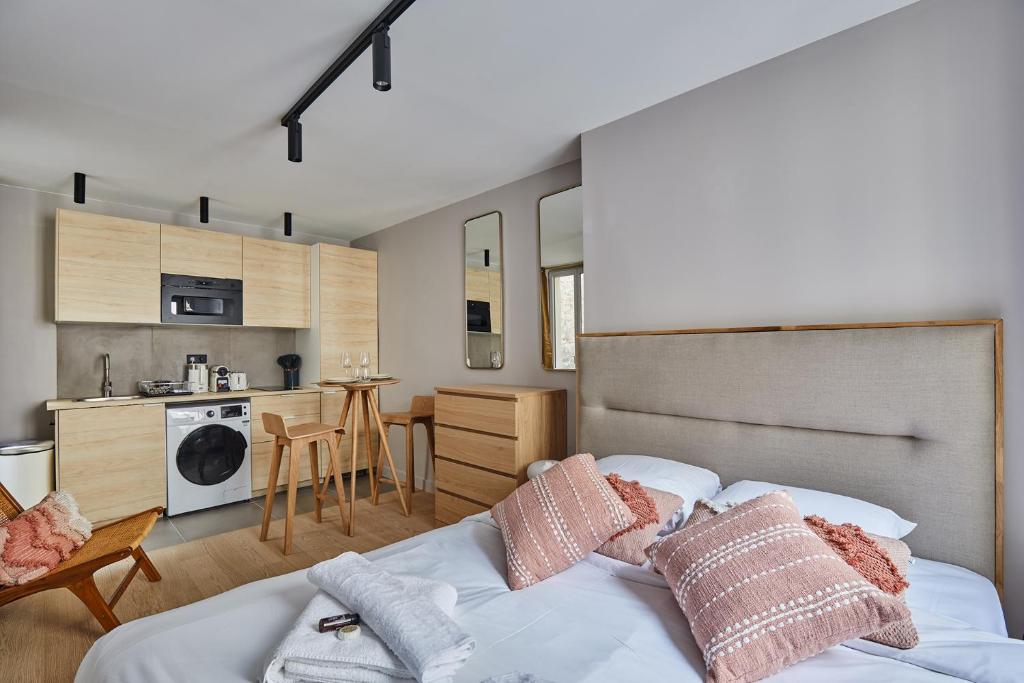 une chambre avec un lit avec des oreillers dessus dans l'établissement Studio Tour Eiffel by Studio prestige, à Paris