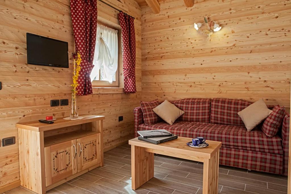 a living room with a couch and a tv at Chalet Camping Faè 4 - Trilocale in Madonna di Campiglio