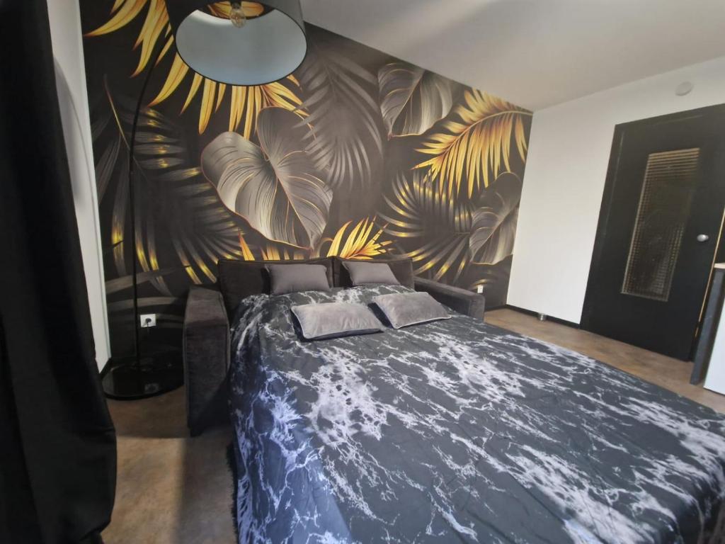 - une chambre dotée d'un lit bleu et d'une fresque murale fleurie dans l'établissement Appartement spacieux MULHOUSE, à Mulhouse