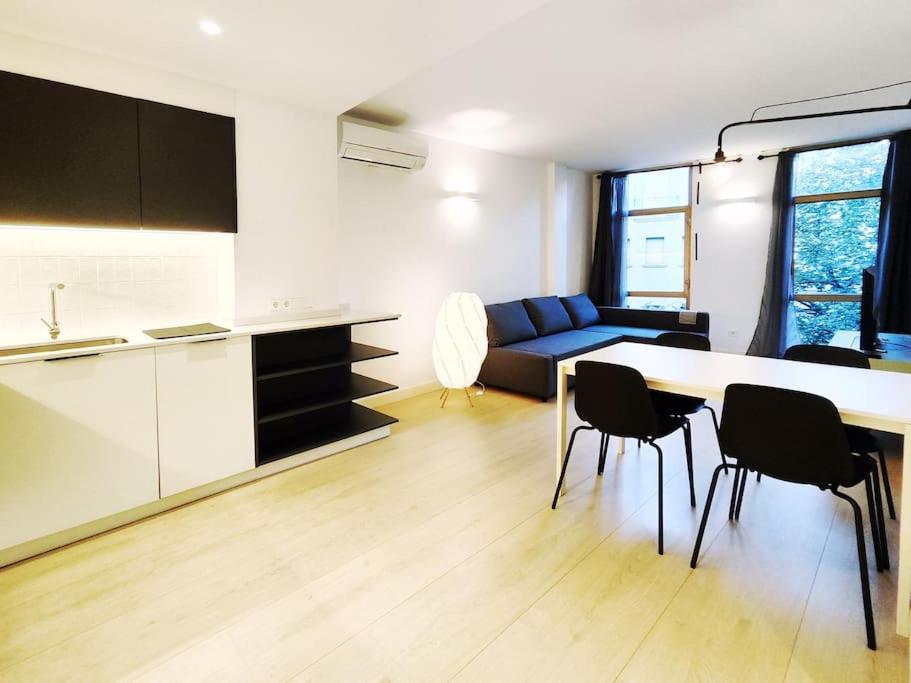 a kitchen and a living room with a table and chairs at Moderno Apartamento en Terrassa Centro in Terrassa