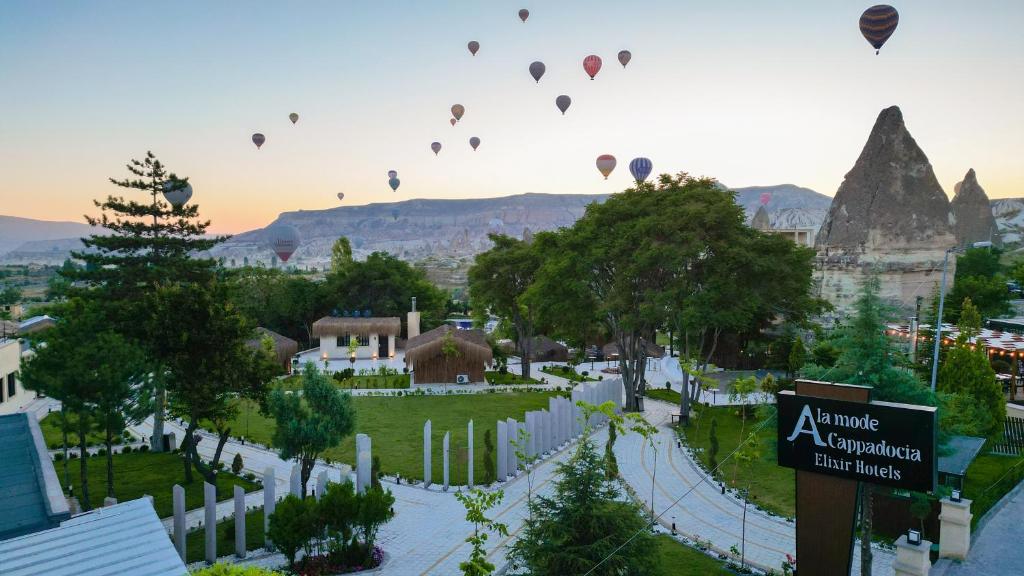 un grupo de globos de aire caliente volando sobre una ciudad en A la mode Cappadocia, en Göreme