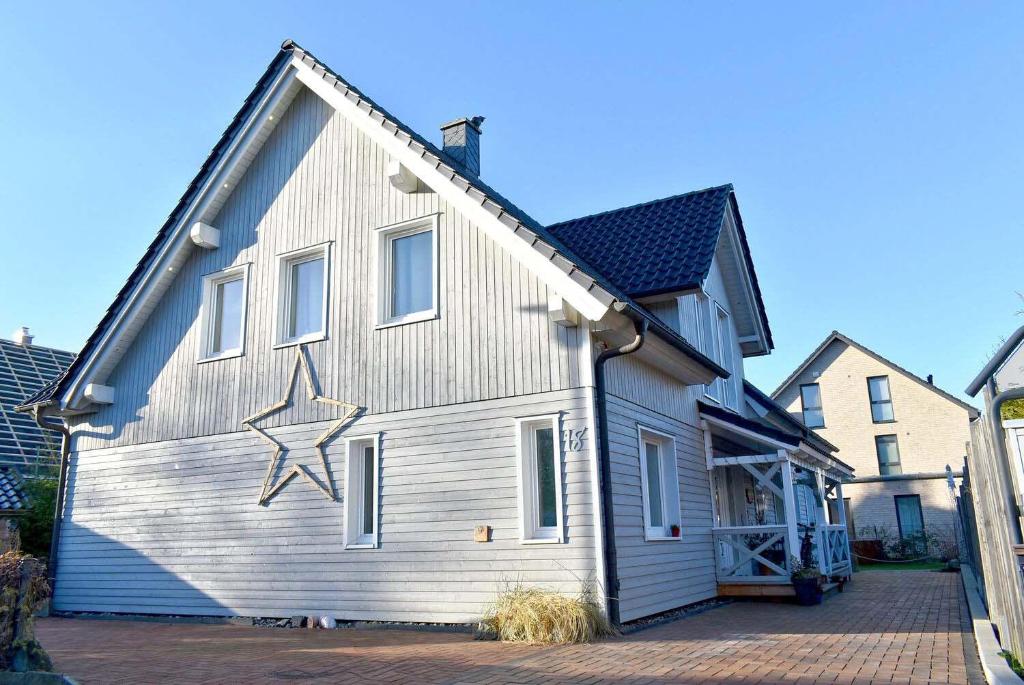 Una casa con una estrella pintada a un lado. en Lütt Hus an de See Ferienwohnung, en Niendorf