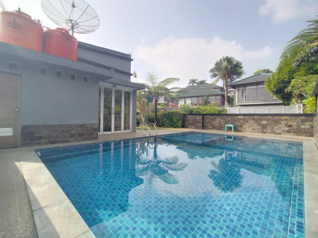a swimming pool in front of a house at Villa Bukit Danau Lot 14 in Cinengangirang