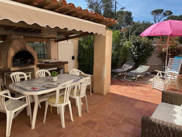 d'une terrasse avec une table, des chaises et un four extérieur. dans l'établissement Maison élégante à 100 m de la mer, à Fréjus
