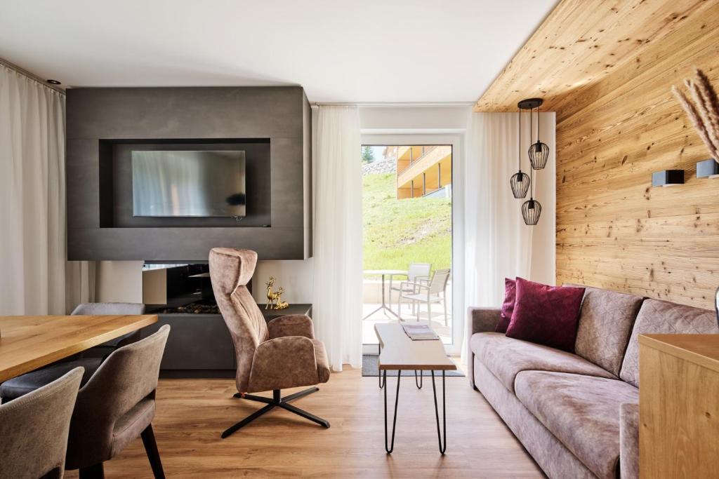 a living room with a couch and a table at Alpenstolz Damüls Haus 3 - Stilvoll urlauben in den Bergen in Damuls