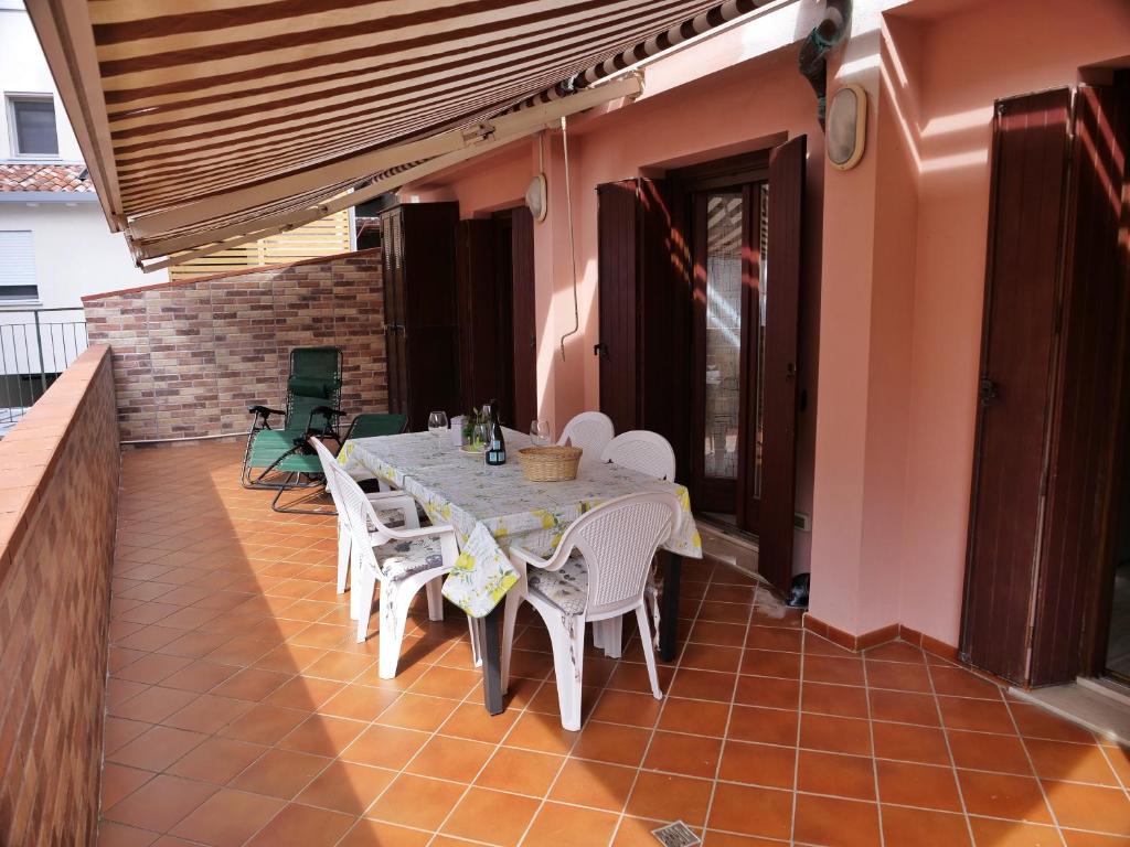 un tavolo da pranzo e sedie su un patio di BigTerrace - ampio monolocale con cameretta e spaziosissimo terrazzo a Grado
