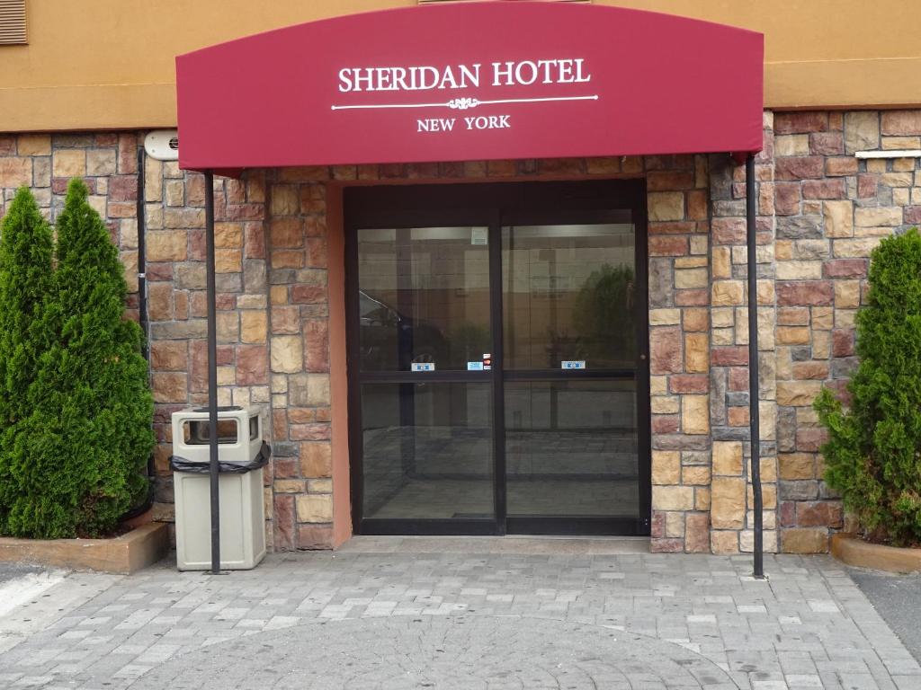 a building with a sign on the front of it at Sheridan Hotel in Bronx