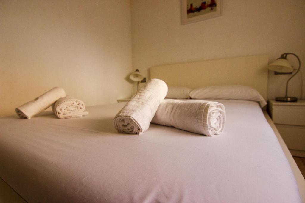 two rolled towels on a bed in a bedroom at RentalSevilla en la Macarena in Seville