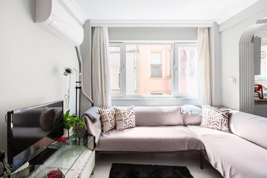 イスタンブールにあるPractical and Cozy Flat Near Taksim İstikalの白いソファと窓のあるリビングルーム