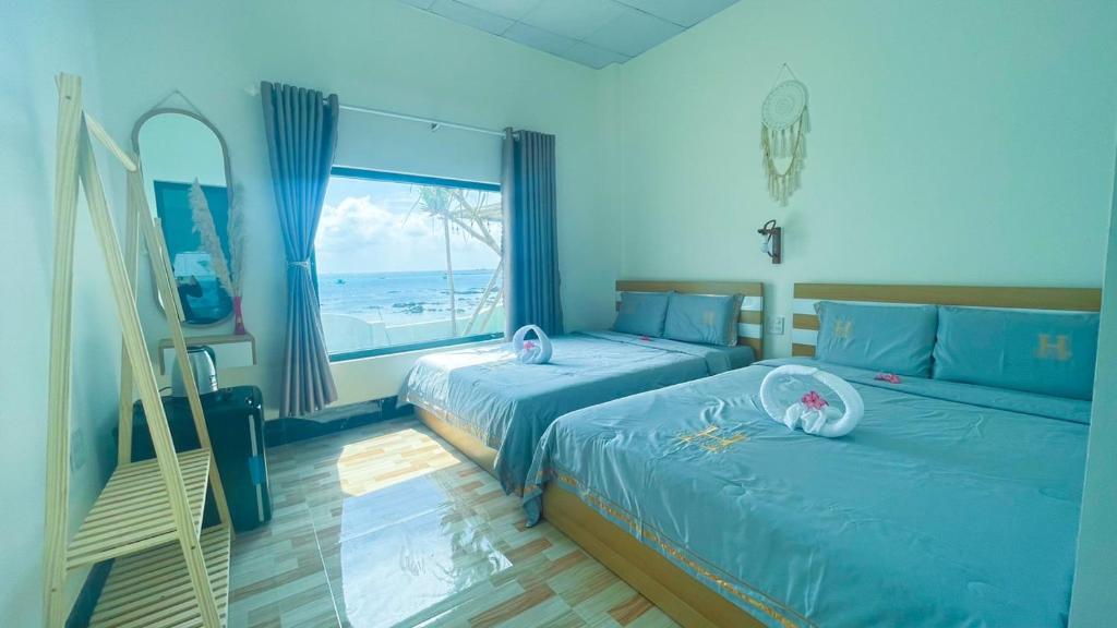 een slaapkamer met 2 bedden en een groot raam bij Homestay, Villa Thùy Dương 2, đảo Phú Quý in Cu Lao Thu