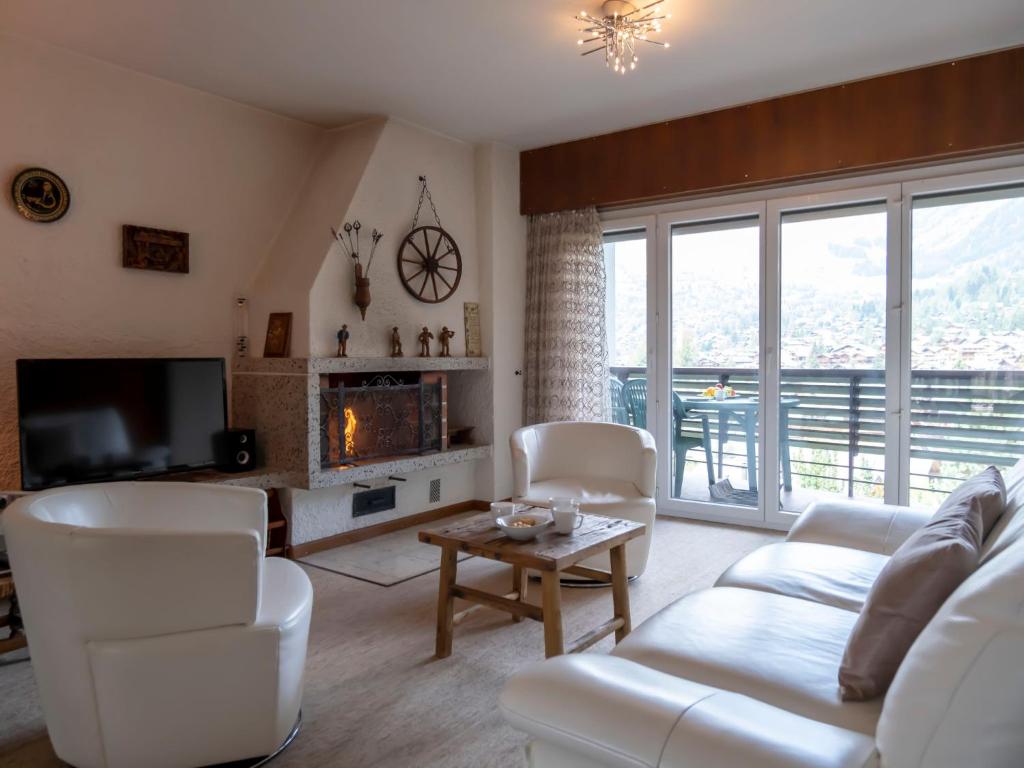 een woonkamer met witte meubels en een open haard bij Apartment Les Girolles A59 by Interhome in Verbier