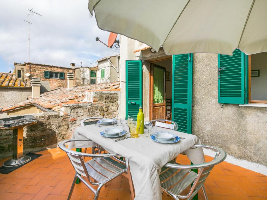 een tafel met stoelen en een parasol op een balkon bij Apartment Serena by Interhome in Montecatini Val di Cecina