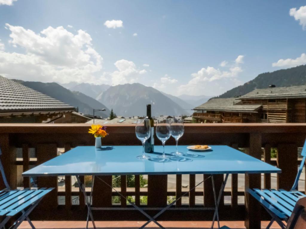 - une table avec des verres à vin sur un balcon avec des montagnes dans l'établissement Apartment Pierreval 18 by Interhome, à Verbier