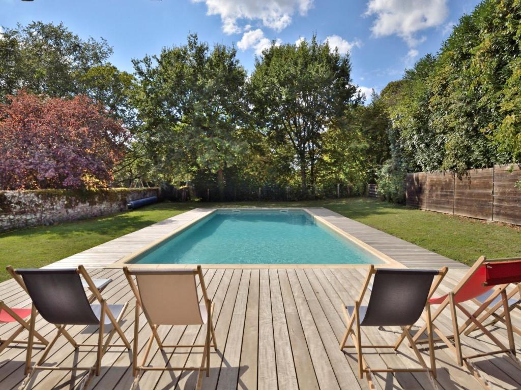 a swimming pool with chairs on a wooden deck at Holiday Home Langevine by Interhome in Thorigné-dʼAnjou