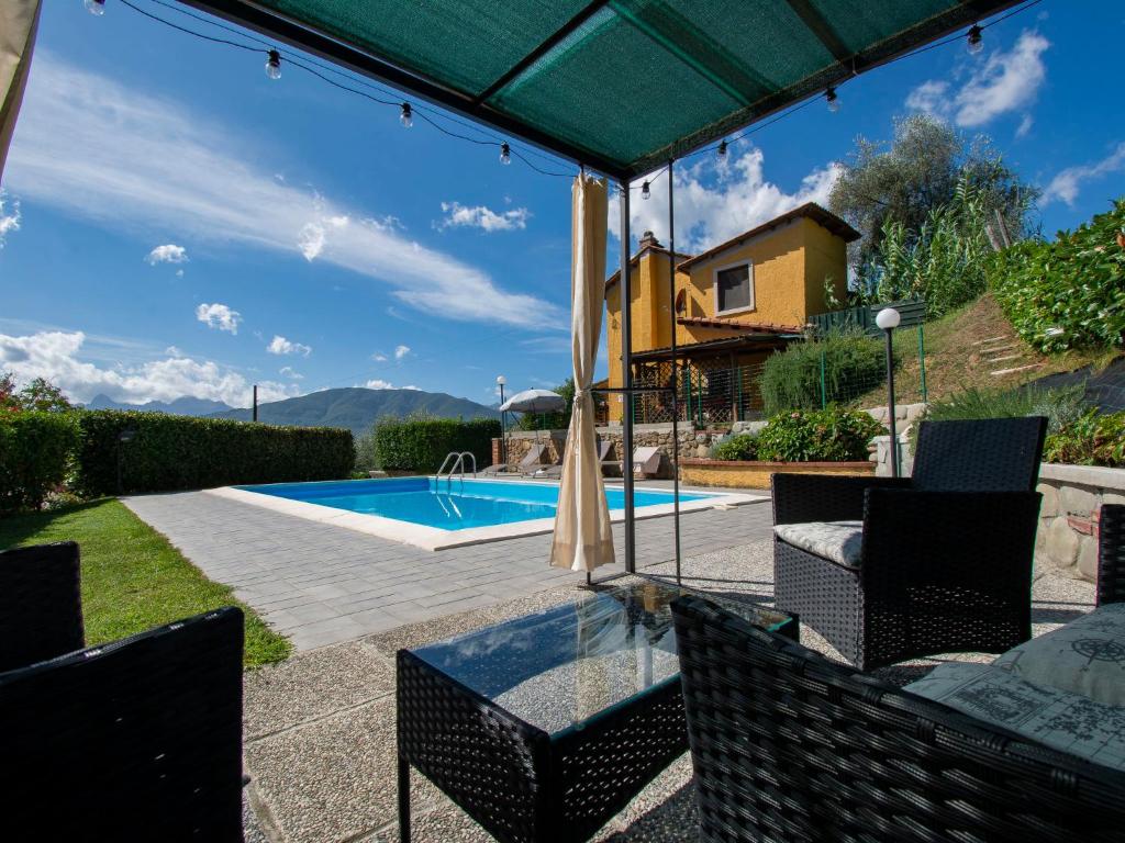 a patio with a table and chairs and a swimming pool at Holiday Home Michael e Patrick by Interhome in Magnano