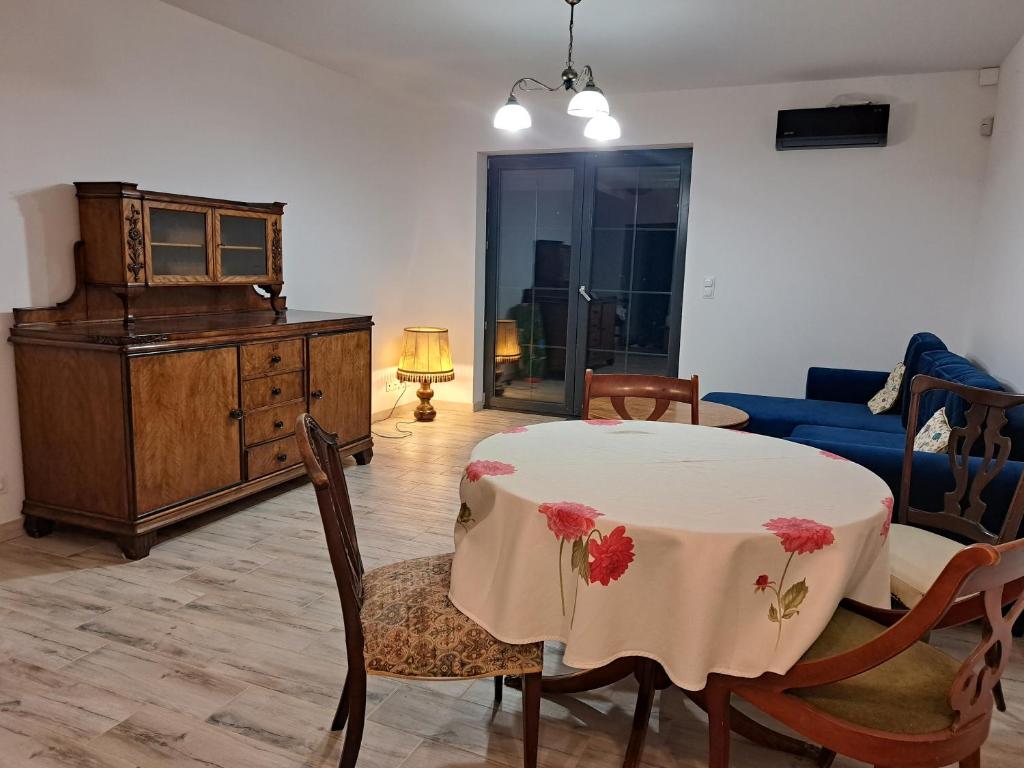 ein Wohnzimmer mit einem Tisch und einem blauen Sofa in der Unterkunft Honey House in Gęsiniec