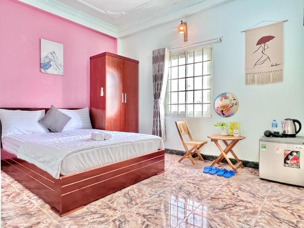 a bedroom with a bed and a pink wall at Tumy homestay Sai Gon in Ho Chi Minh City