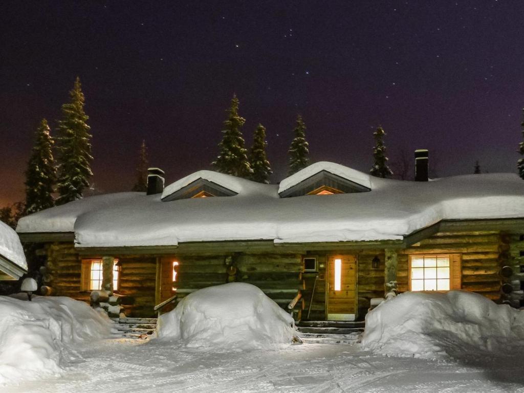 a log cabin in the snow at night at Holiday Home Kuruhovi b by Interhome in Ruka