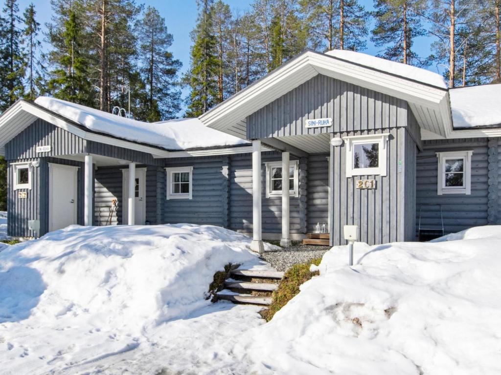 a blue house with snow in front of it at Holiday Home Sini-ruka 1 by Interhome in Ruka