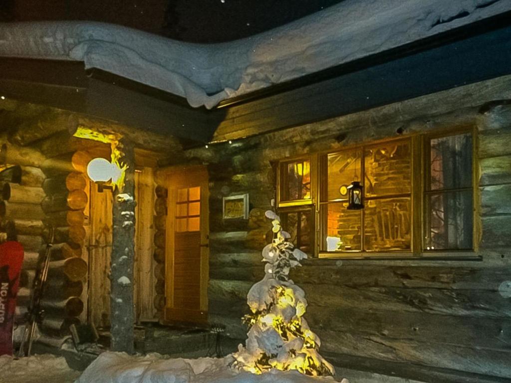 a house with a christmas tree in front of it at Holiday Home Lapinkoto by Interhome in Ruka