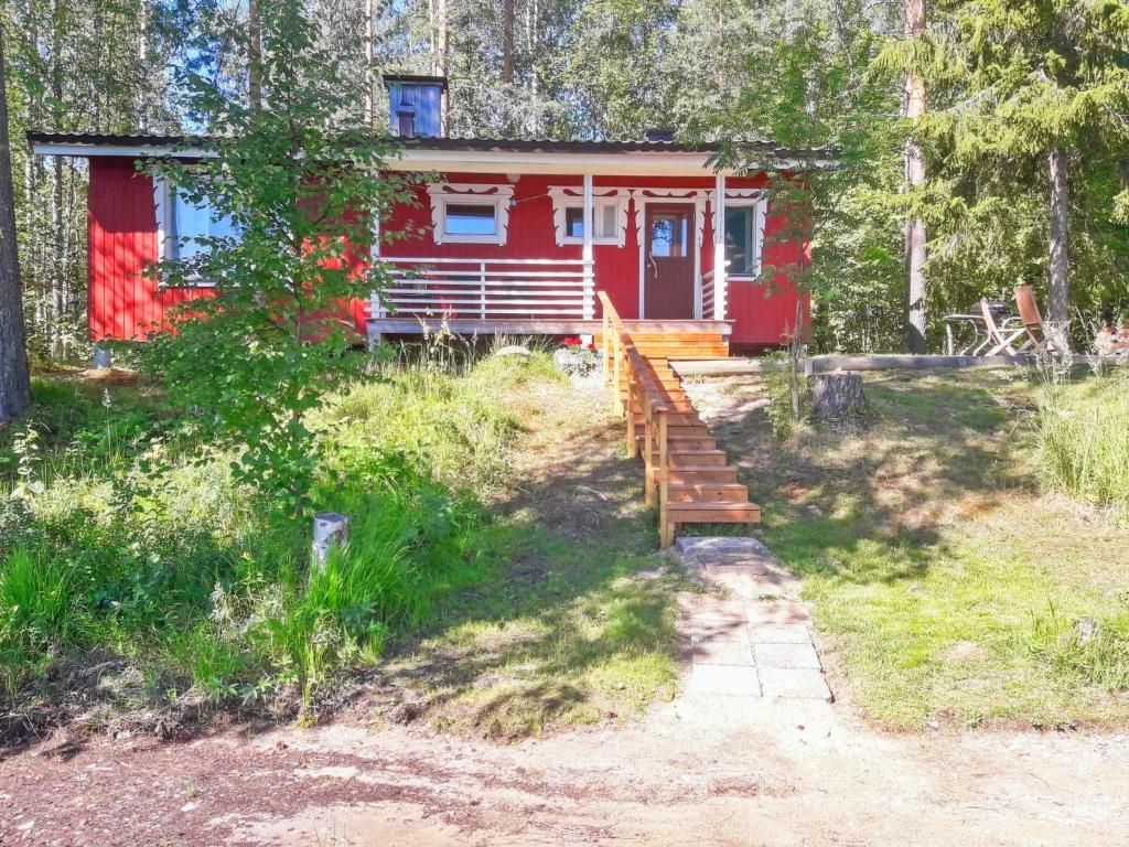 a red house with a staircase in front of it at Holiday Home Taimisto by Interhome in Juhanala