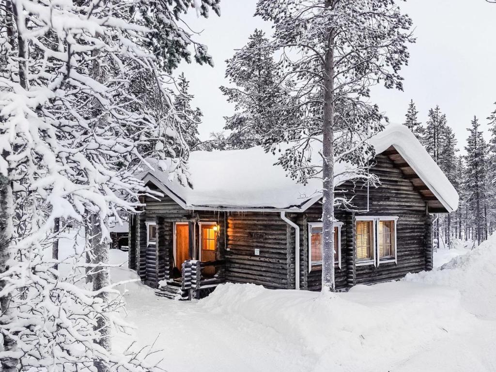 a cabin in the woods covered in snow at Holiday Home Villemi by Interhome in Saariselka