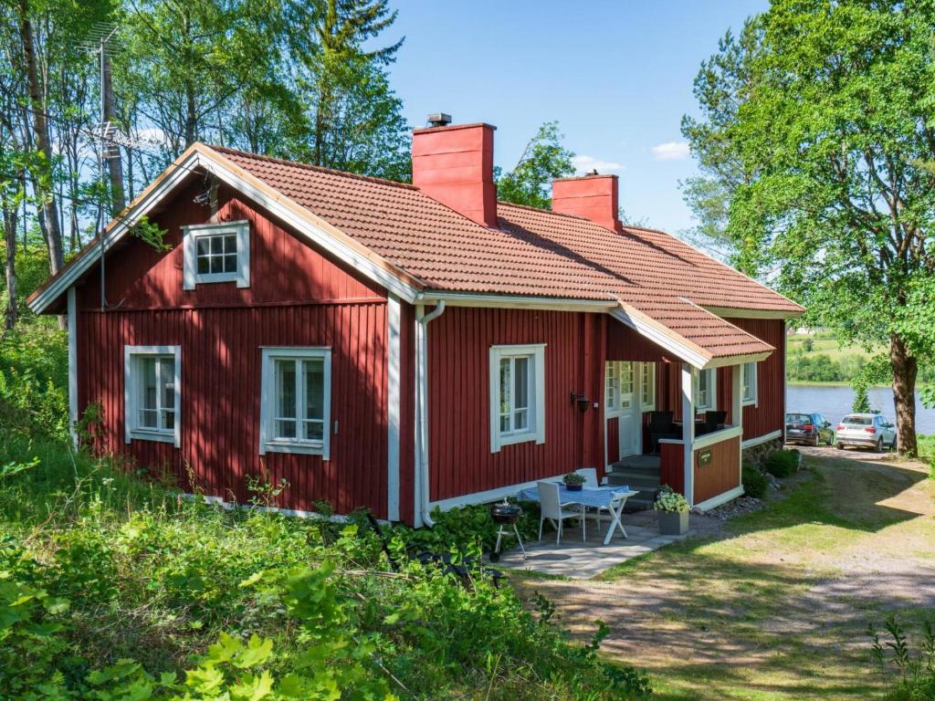 una casa roja con una mesa de picnic delante de ella en Holiday Home Pikkupehtoori by Interhome, en Hirsjärvi