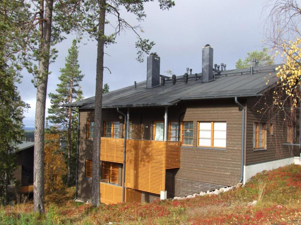 a house in the woods with a black roof at Holiday Home Karhunvartijan tupa a6 by Interhome in Ruka