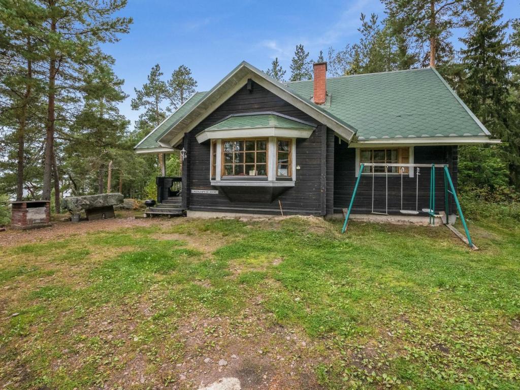 een klein zwart huis met een tuin bij Holiday Home Kotkanpesä by Interhome in Askainen