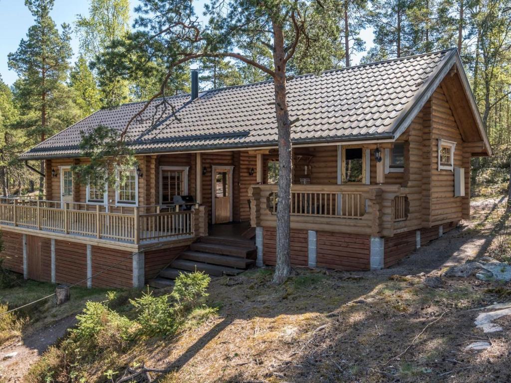 a log cabin in the woods with a porch at Holiday Home Lokki by Interhome in Karuna