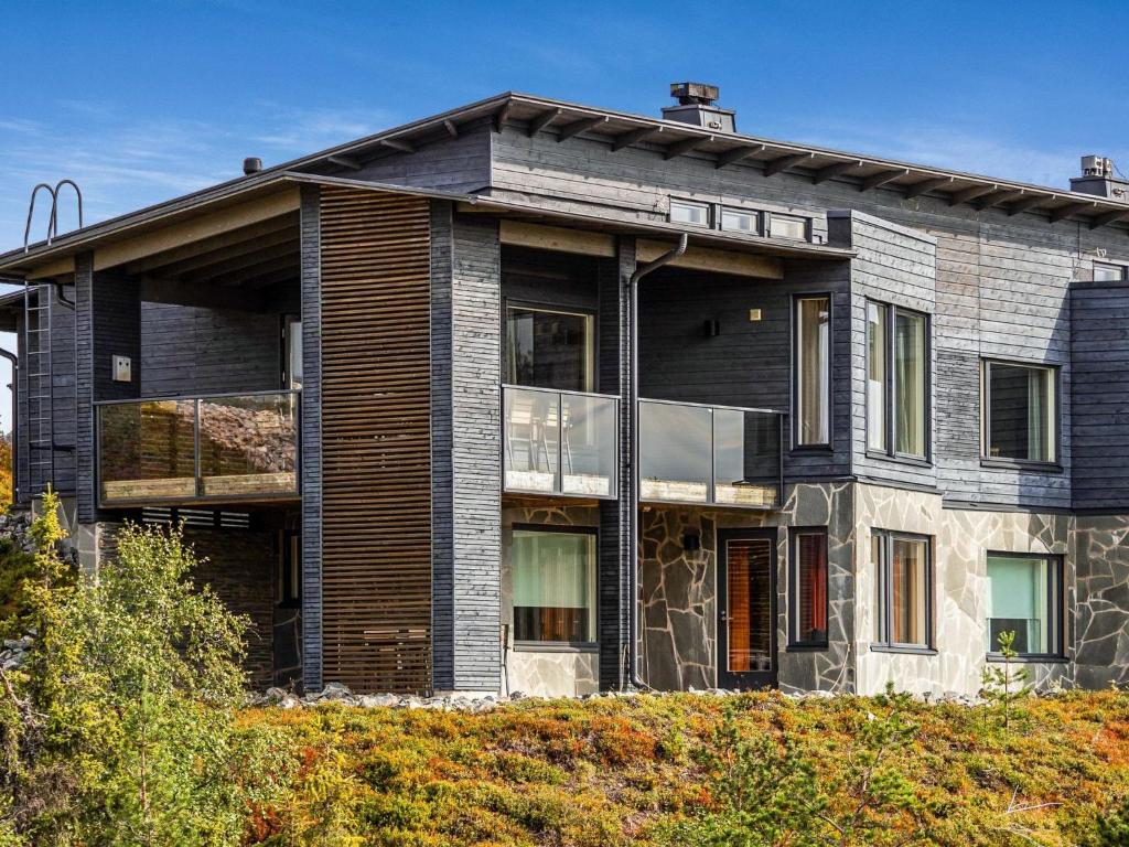 a large house with glass windows on a hill at Holiday Home Rukavuorenhuippu 23 a by Interhome in Ruka