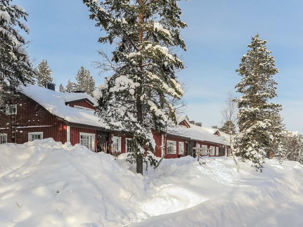 een huis bedekt met sneeuw naast twee bomen bij Holiday Home Soidinaukea b 20 by Interhome in Saariselkä