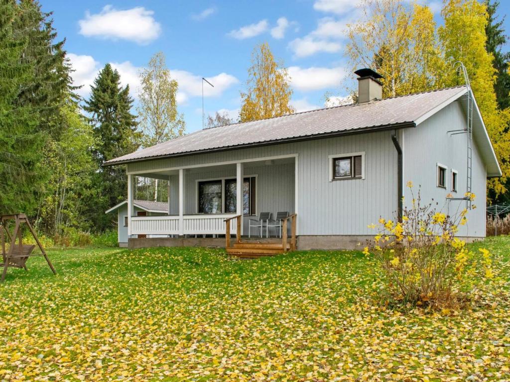 uma casa branca com um alpendre num quintal em Holiday Home Iltarauha by Interhome em Ruvaslahti