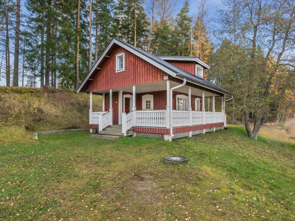 a red house with a white porch on a field at Holiday Home Satulinna by Interhome in Matildedal