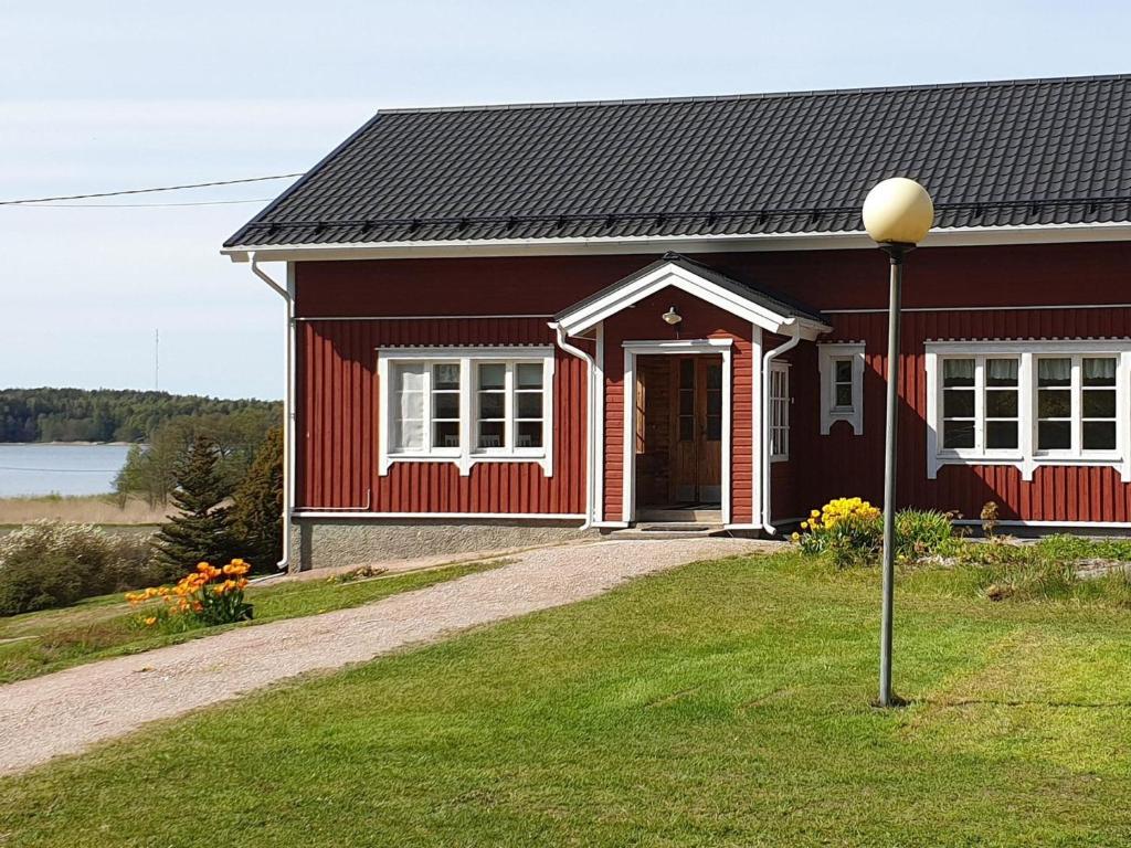 une maison rouge avec une porte rouge et un éclairage de rue dans l'établissement Holiday Home Villa pääsky by Interhome, à Karuna