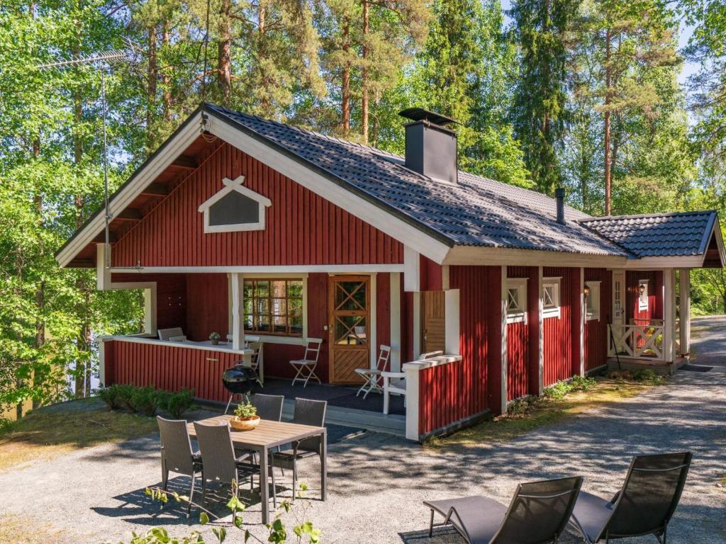 a red barn with a table and chairs at Holiday Home Satakieli by Interhome in Hirsjärvi