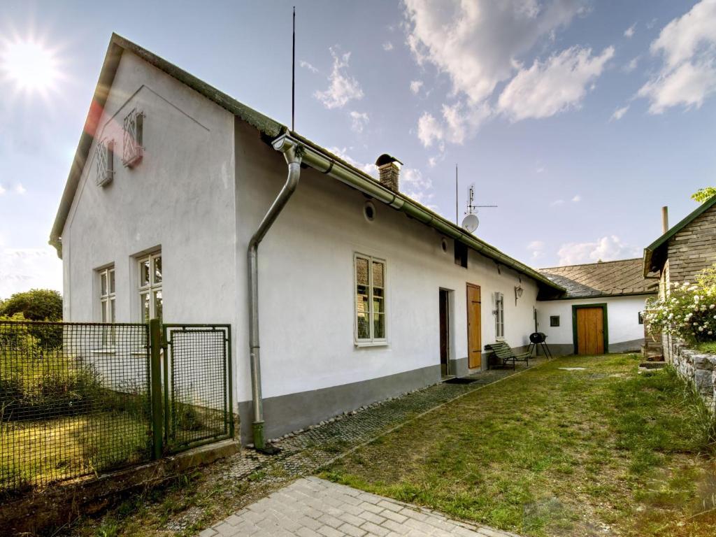 a white house with a fence in front of it at Holiday Home Praskolesy by Interhome in Praskolesy