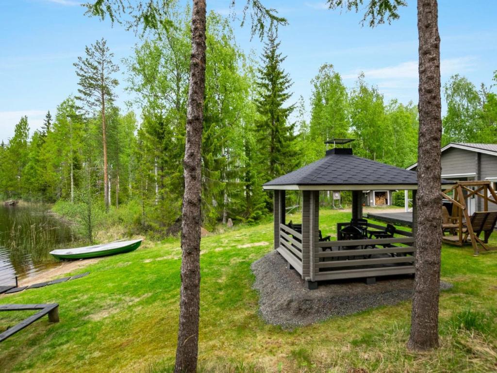 a gazebo in the middle of a yard with trees at Holiday Home Lehtikuusenranta by Interhome in Hankamäki