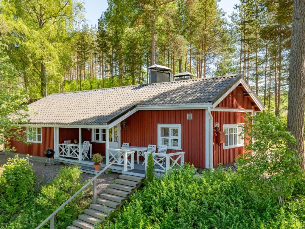 HirsjärviにあるHoliday Home Punatulkku by Interhomeの森の赤いコテージ ポーチ付