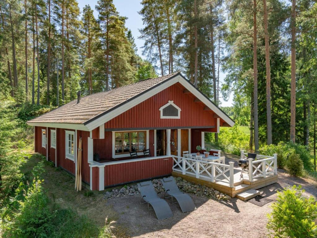 eine rote Hütte mitten im Wald in der Unterkunft Holiday Home Kivitasku by Interhome in Hirsjärvi