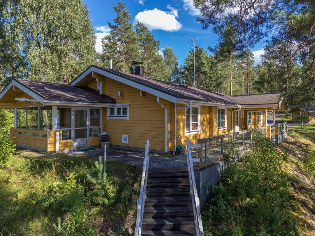 a house in the woods with a staircase leading up to it at Holiday Home Unnukkamaja by Interhome in Leppävirta