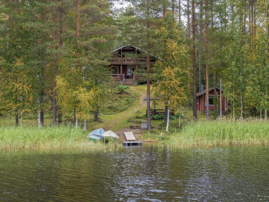 une cabane en rondins dans les bois à côté d'un lac dans l'établissement Holiday Home Mäntyrinne by Interhome, à Ruottila