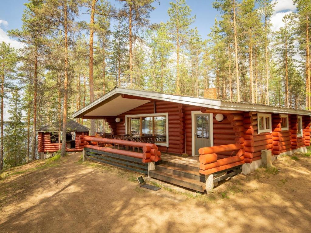 a log cabin in the woods with a porch at Holiday Home Pohosniemi by Interhome in Huuhanaho