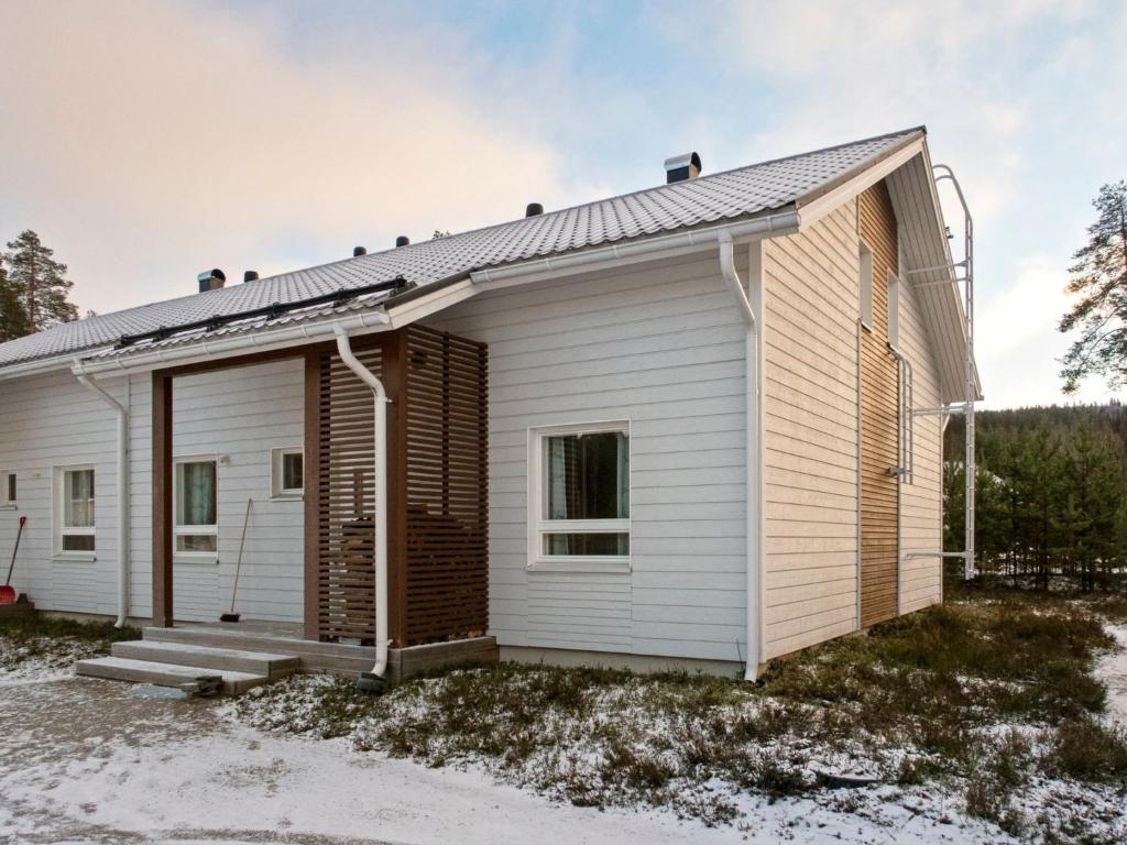 ein kleines weißes Haus mit einer Veranda in der Unterkunft Holiday Home 4 seasons a 2 by Interhome in Lahdenperä